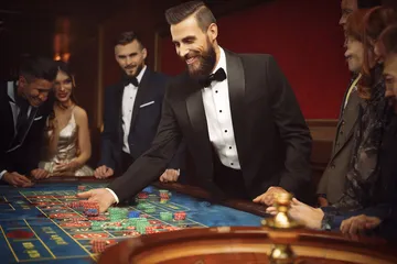 A close-up shot of golden coins falling around a spinning roulette wheel, representing immersive casino action at MALIWIN.
