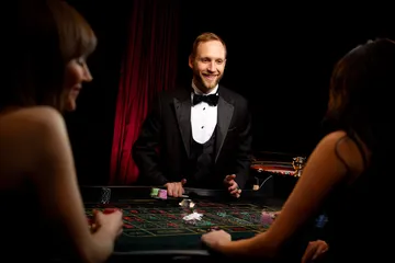 A player using their smartphone during a festive local event, representing MALIWIN’s fully mobile-friendly casino.